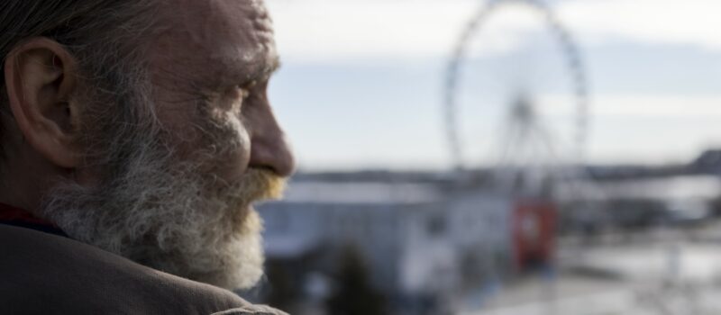 Image illustrant un homme qui regarde la ville au loin.