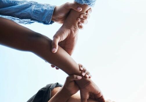 Un groupe de personnes qui entrelacent leurs mains les unes sur les autres