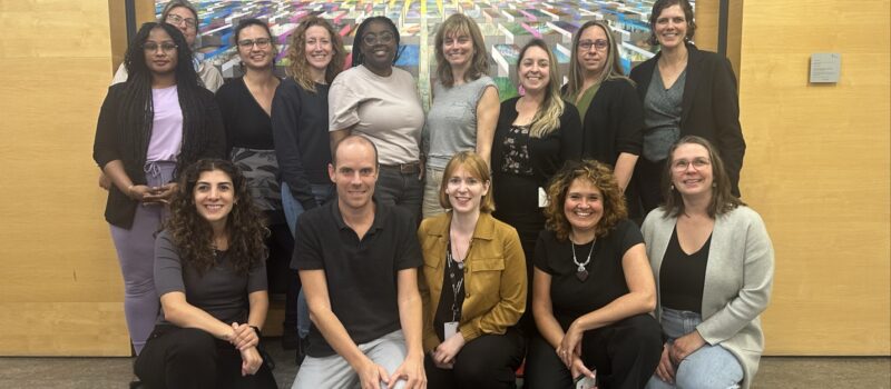 Membres de l'équipe de la Division partenariats et interventions territoriales composée de 14 personnes souriantes. Les personnes sont côte à côte, disposées en deux rangées, assis ou debout. L'ambiance semble conviviale.